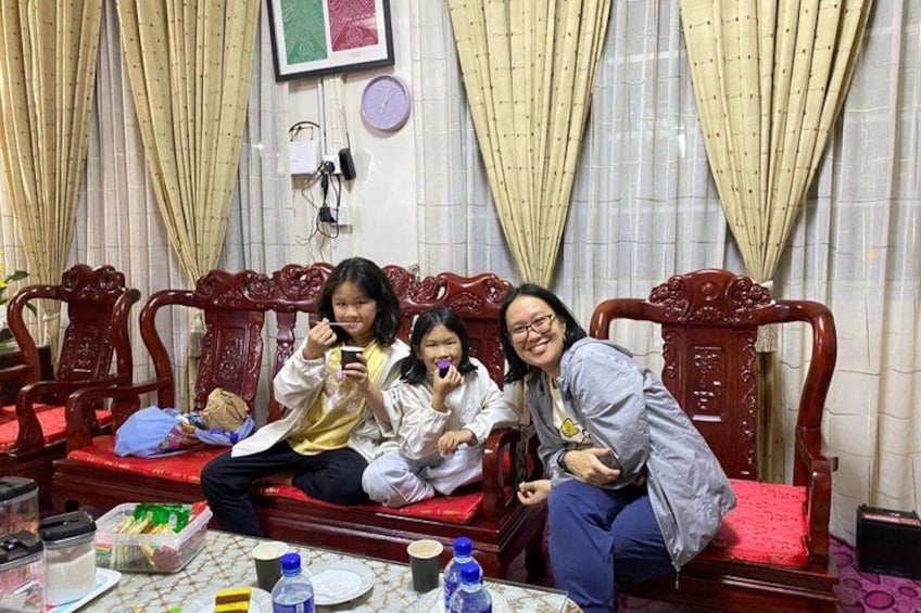 Three people sitting on a red sofa with a table in front of them. 3