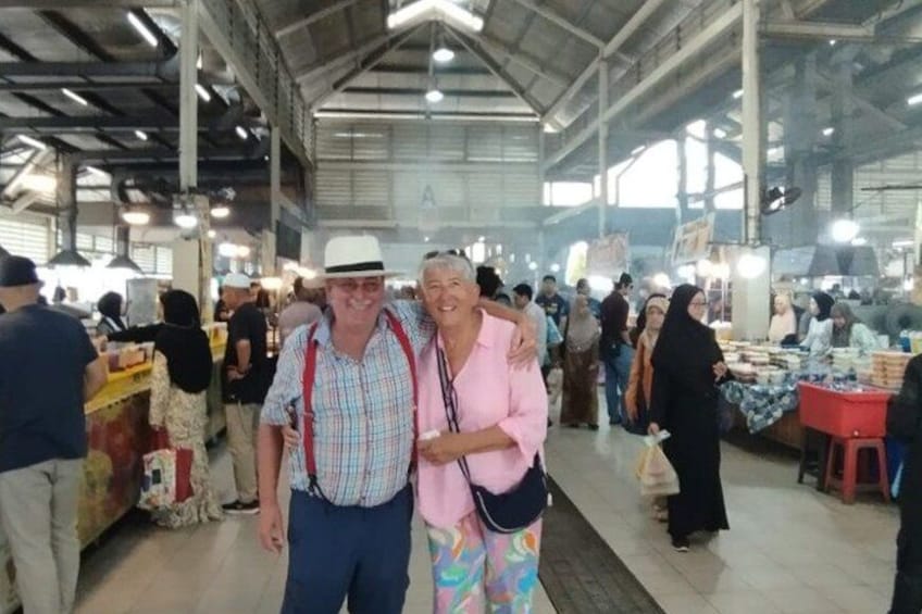 An indoor market with people browsing and vendors selling goods. 3