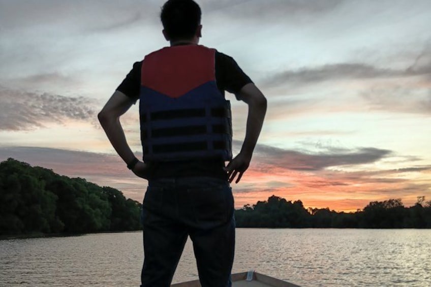 A person standing by a body of water during sunset. 5