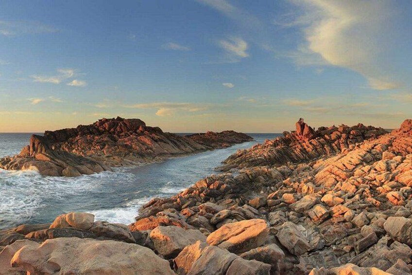Une côte rocheuse où les vagues s’écrasent contre les rochers sous un ciel dégagé. 5