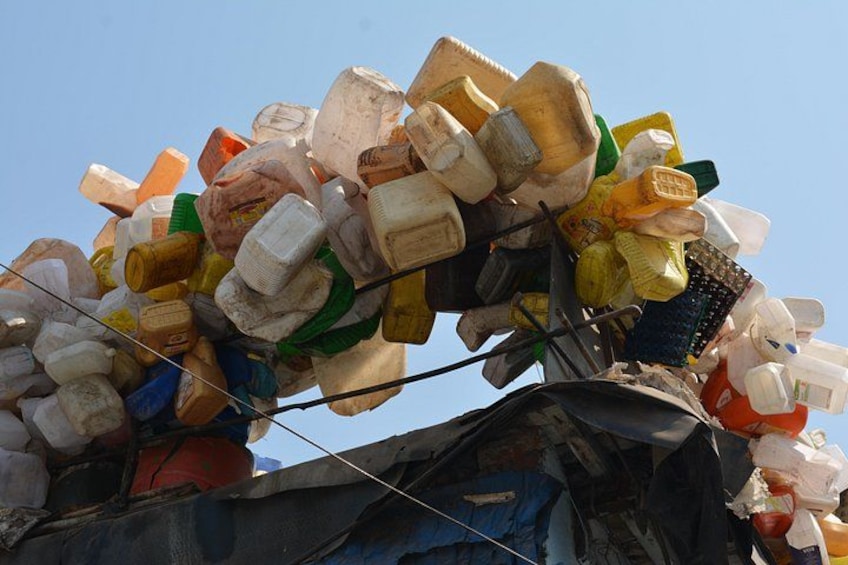 A pile of discarded plastic bottles and containers on a rooftop. 5