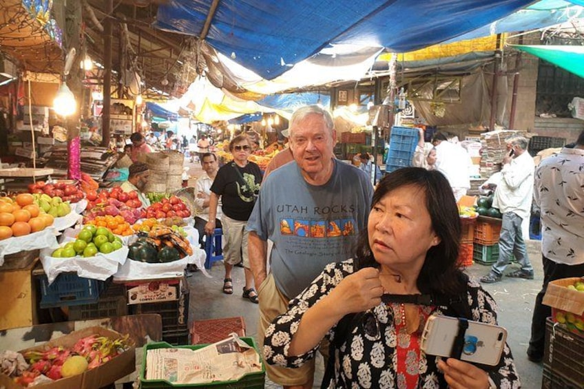 A bustling market with various stalls selling fruits and vegetables. 2