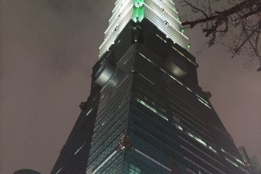 A tall, illuminated skyscraper with a distinctive top section. 3