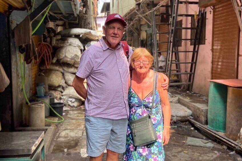 Une ruelle étroite avec des marches en pierre, une échelle et une femme vêtue d’une robe  à fleurs tenant un sac à main. 1