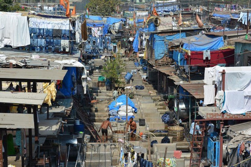 Un barrio marginal muy poblado con viviendas precarias, estrechos senderos y tanques de agua a la vista. 1