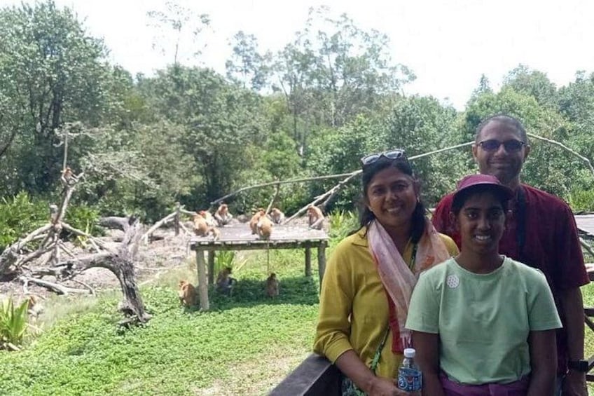Un grupo de personas en un entorno natural, con una estructura de madera y gallinas de fondo. 1