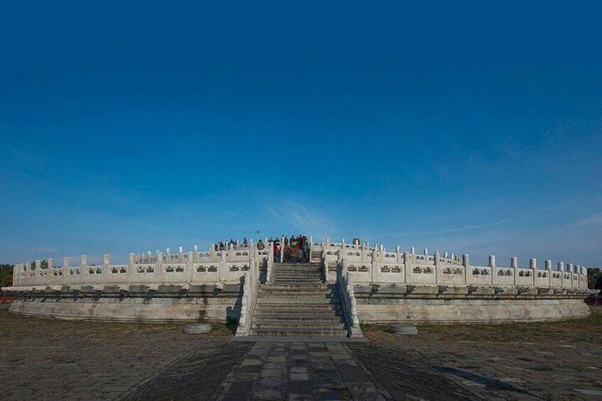 A large white structure with steps leading up to it, surrounded by a clear blue sky. 4