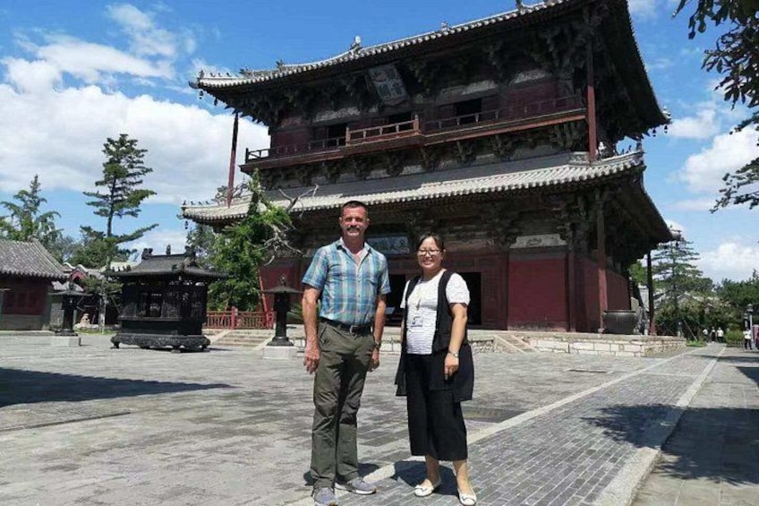 A traditional building with a multi-tiered roof and a stone pathway in front. 2