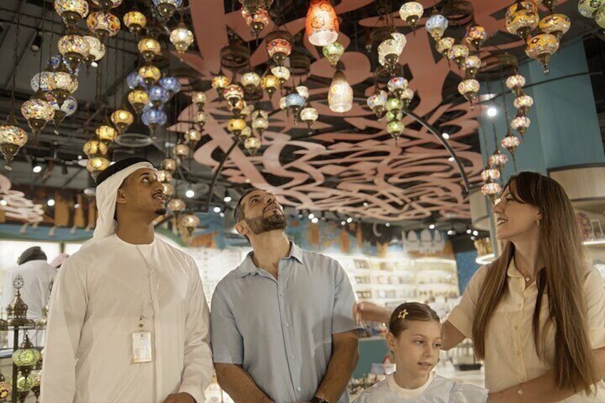 A group of people in a shopping mall with hanging decorative lights. 1