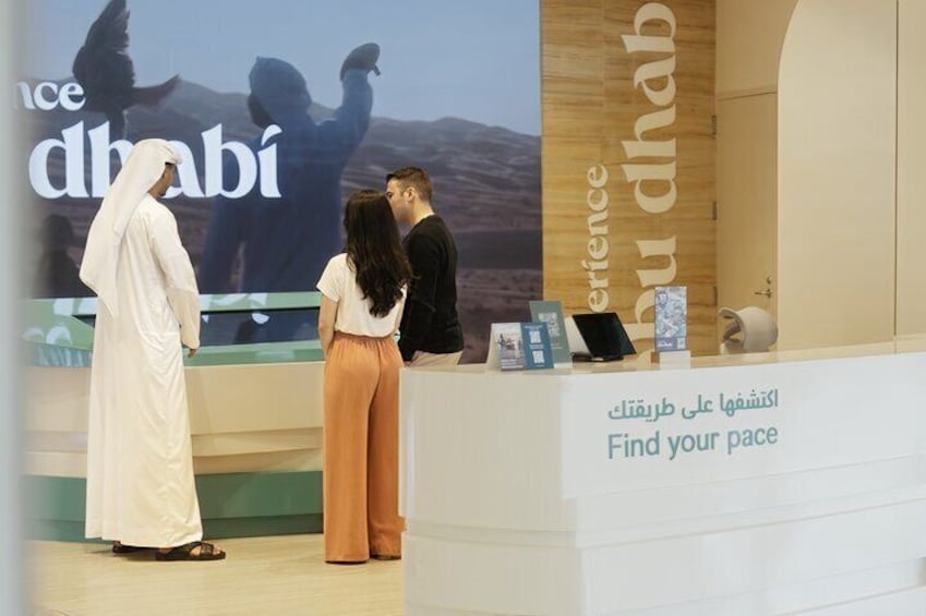 A reception desk with a sign that reads "Find your pace" and a backdrop with the word "Dubai". 4