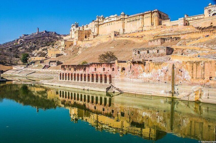 A historic fort with a river in the foreground reflecting its architecture. 1