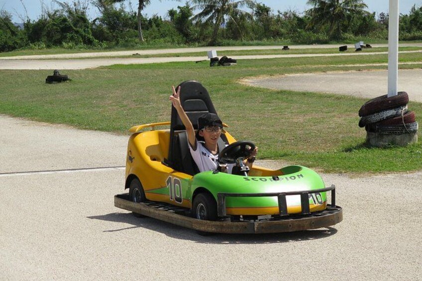 A person driving a green and yellow bumper car with the number 10 on it. 5