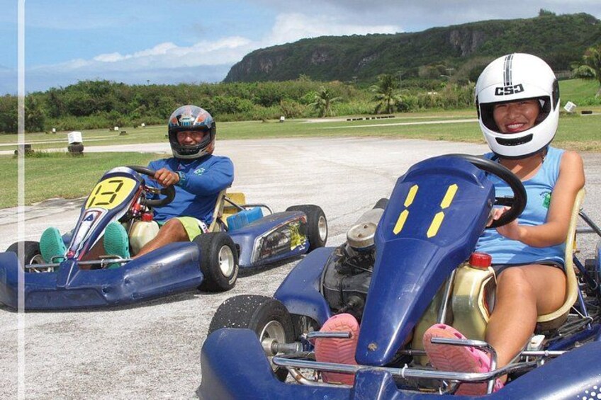 Two go-karts on a track with a mountainous landscape in the background. 3