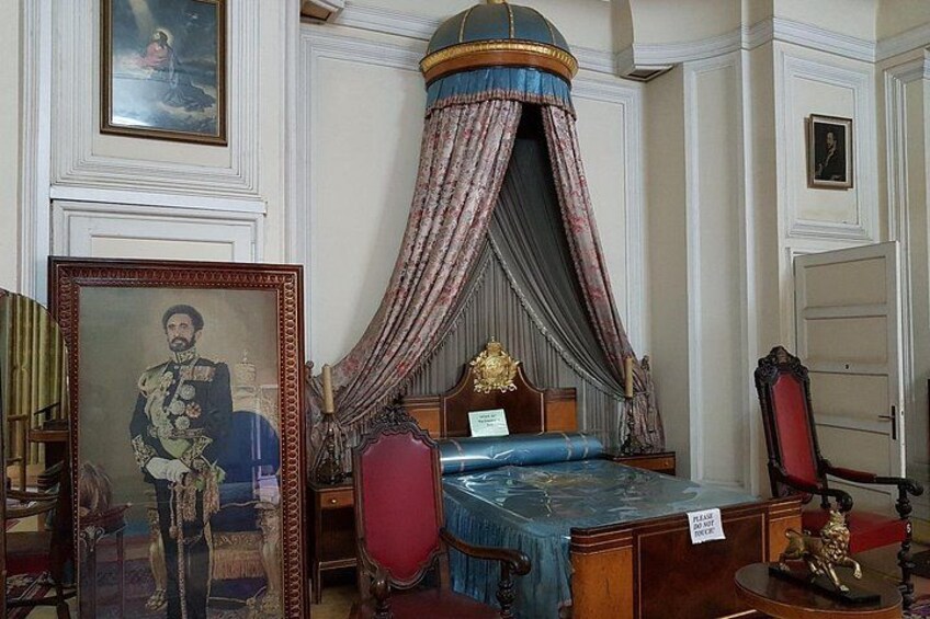 Un dormitorio con cama con dosel, un retrato y un cuadro grande. 5