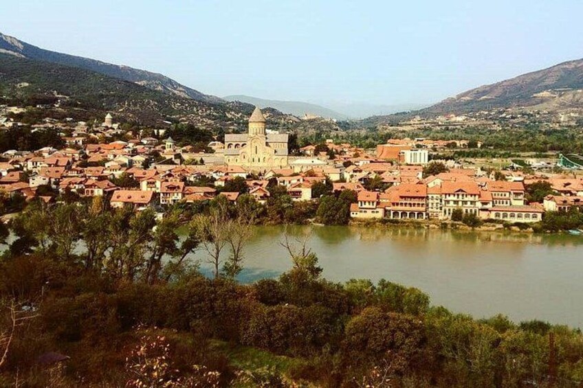 Una cittadina con una chiesa imponente, un lago e colline circostanti. 1