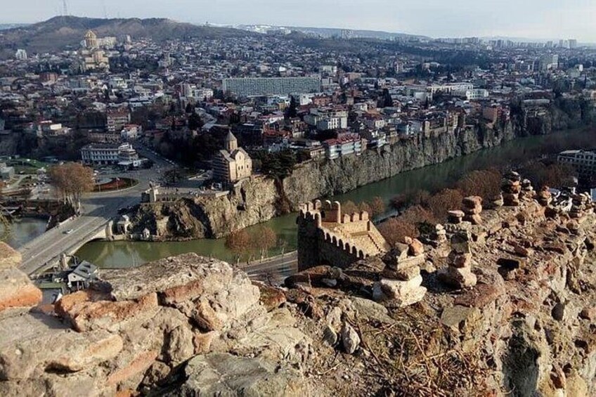 Paesaggio urbano con una struttura imponente simile a una fortezza, un fiume e un ponte. 2