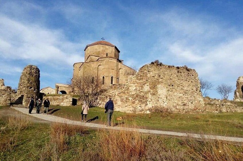 Un edificio storico con una cupola, circondato da rovine e un sentiero. 5