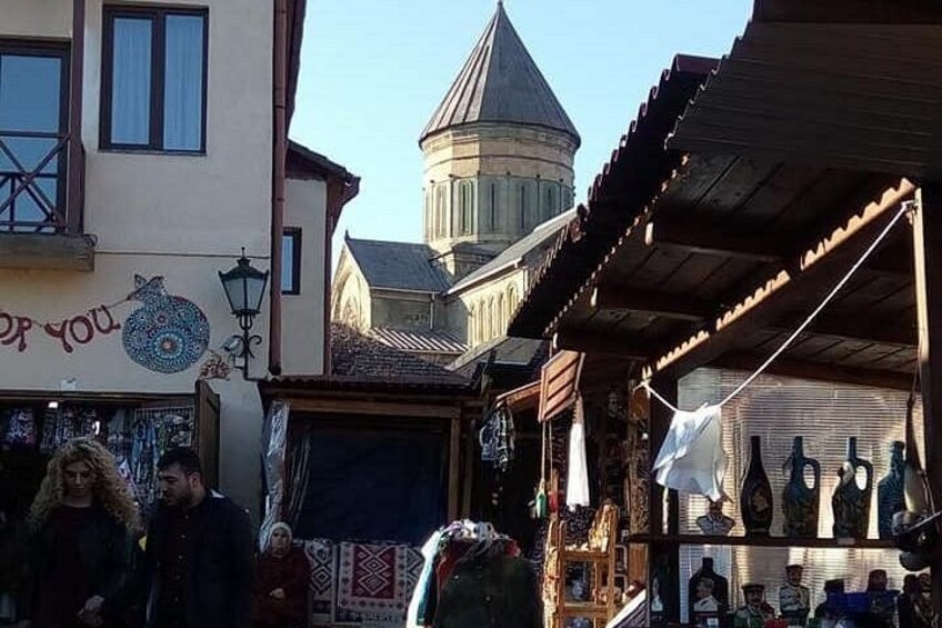 Un mercato rionale con negozi e una torre sullo sfondo. 3