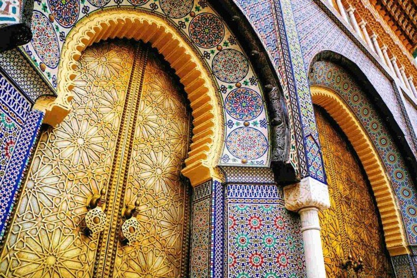 A detailed view of a richly decorated door with intricate geometric patterns and a large archway. 2