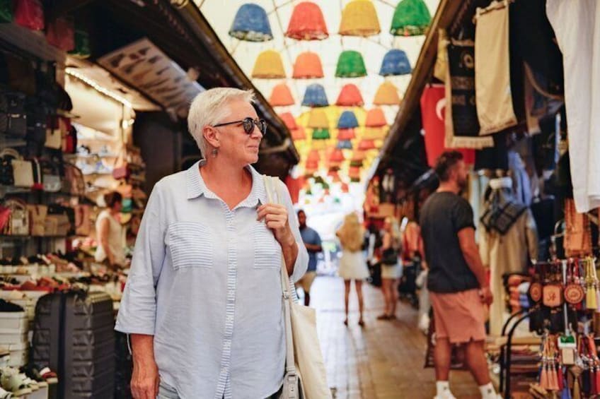 Un mercado con sombrillas de colores sobre la cabeza y varios puestos que venden productos. 4