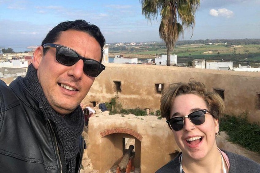 Een man en een vrouw maken een selfie, met een historisch fort op de achtergrond. 5