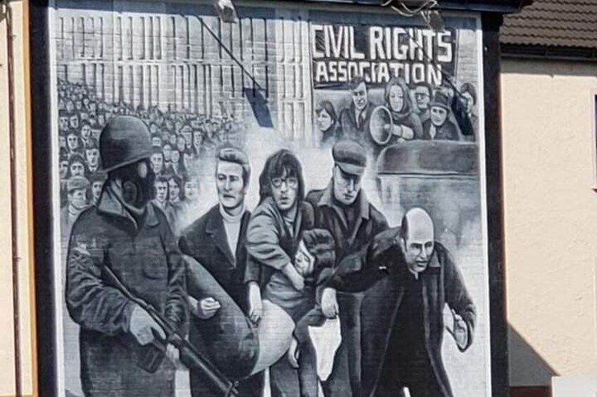 A mural of a civil rights protest with people holding signs and a crowd in the background. 2