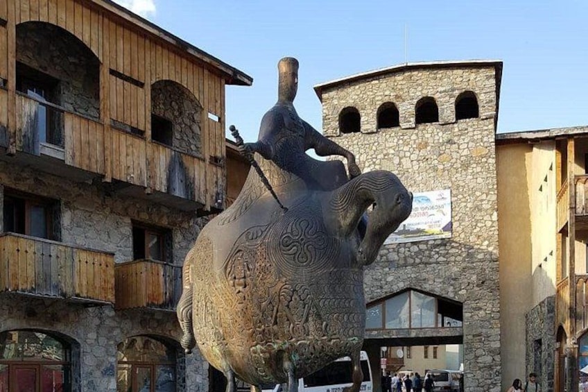 A large bronze sculpture of a man riding a bull in a town square. 2