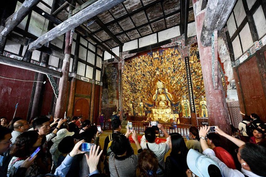 Une grande statue dorée se trouve dans un temple, et une foule de personnes s’y est rassemblée. 4