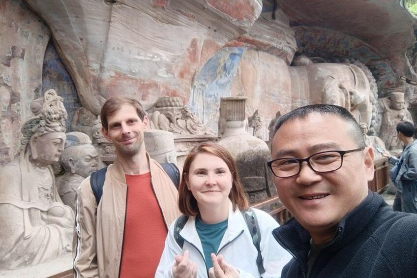 Drei Personen vor alten Steinritzungen. 4