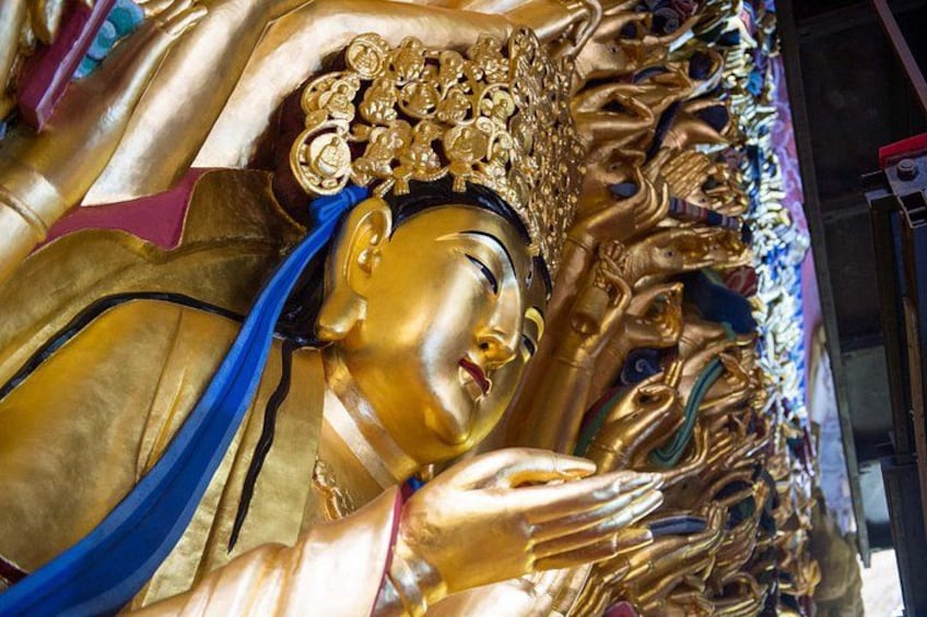 Une grande statue dorée, richement décorée et dotée de nombreuses mains. 5
