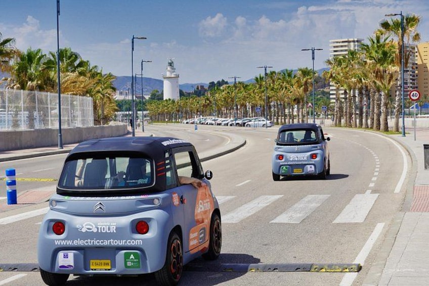 A coastal road with palm trees, a lighthouse, and a blue car with a 'TOUR' decal. 3
