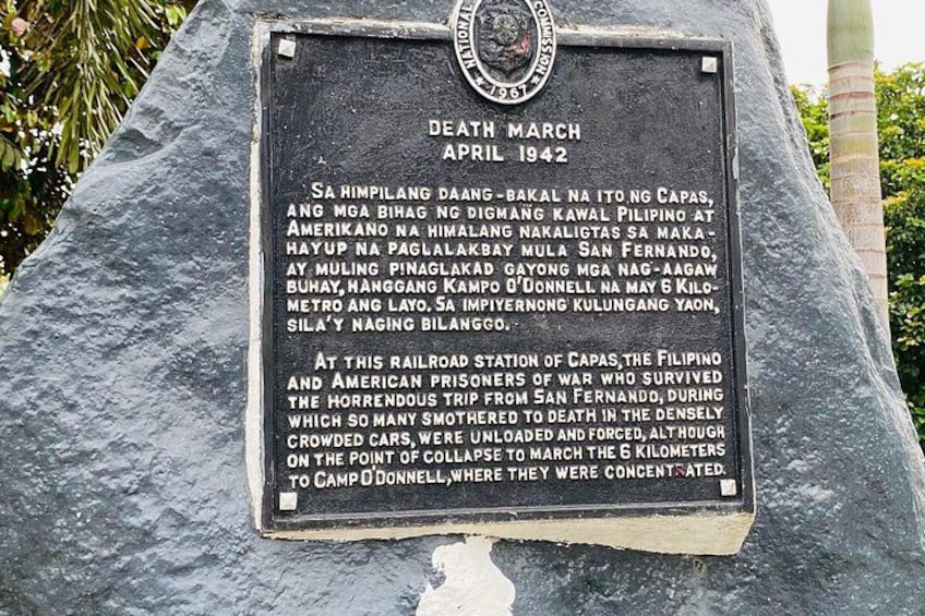 A memorial plaque with text and a seal, set on a stone monument. 4