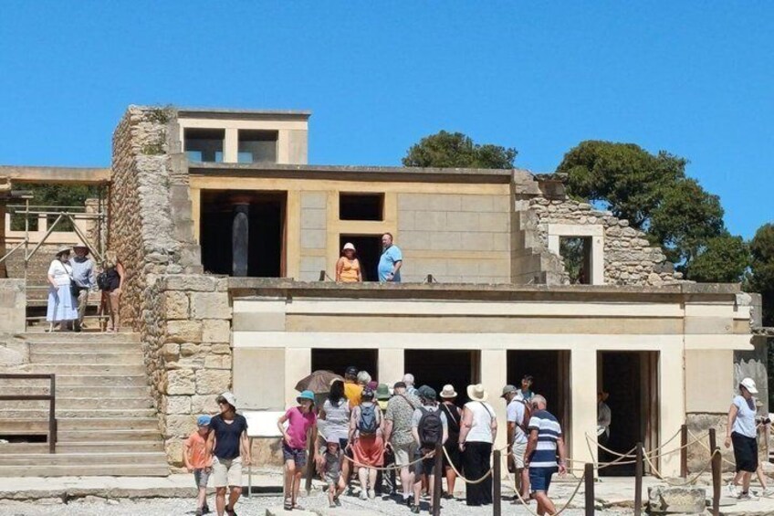 Ein historisches Gebäude mit Touristen, Steinstufen und blauem Himmel. 1