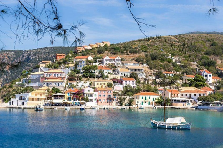 A coastal village with colorful houses, a calm sea, and a boat anchored near the shore. 1