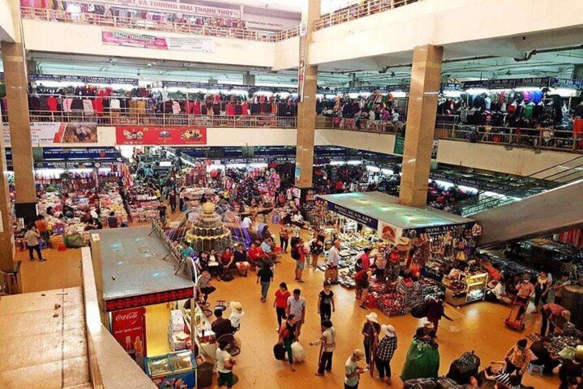 A multi-level indoor market with various stalls and shoppers. 3