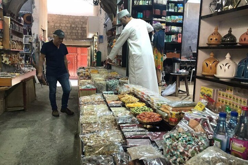 Ein Markt mit verschiedenen Lebensmitteln und einer Person in traditioneller Kleidung. 5