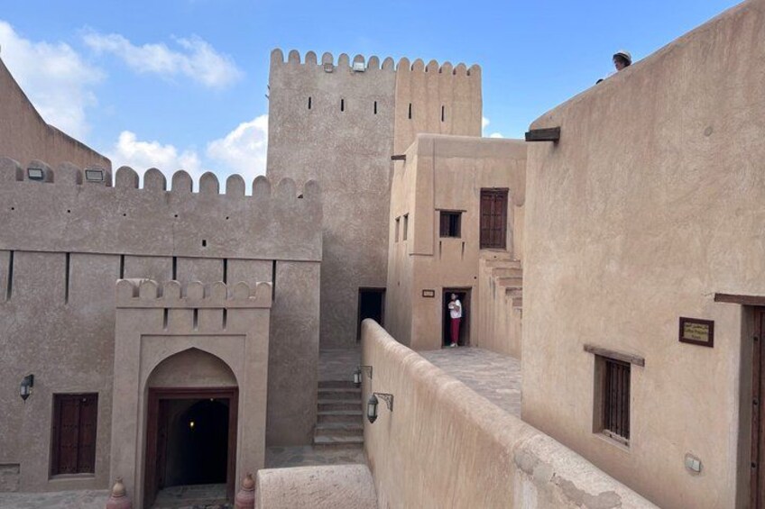 A traditional fortress with a tower, arched entrance, and a staircase leading to the upper levels. 3