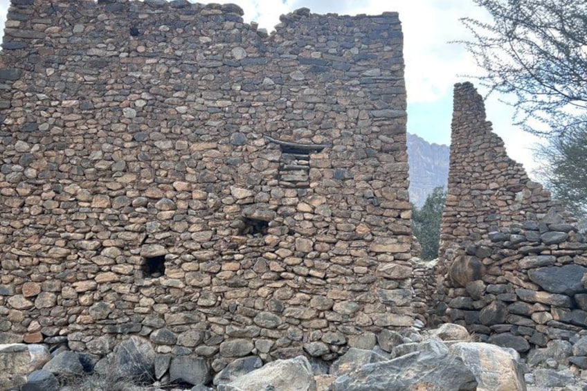 Ancient stone ruins with a stone wall and a small window. 4
