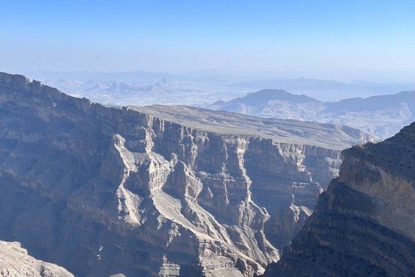 A vast canyon with layered rock formations and a clear sky. 2