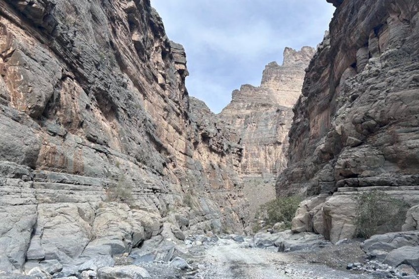 A canyon with layered rock formations and a narrow path. 5