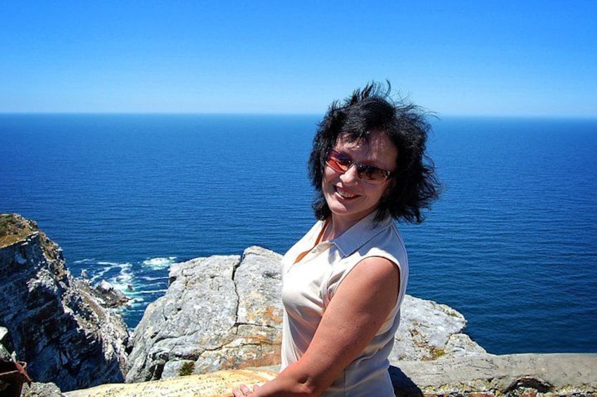 A person standing on a rocky cliff overlooking the ocean. 4
