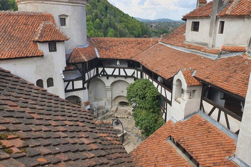 A historic town with red-tiled roofs, white buildings, and a central courtyard. 4