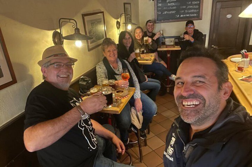Un grupo de personas sentadas en una mesa en un restaurante, sosteniendo bebidas y comida. 3