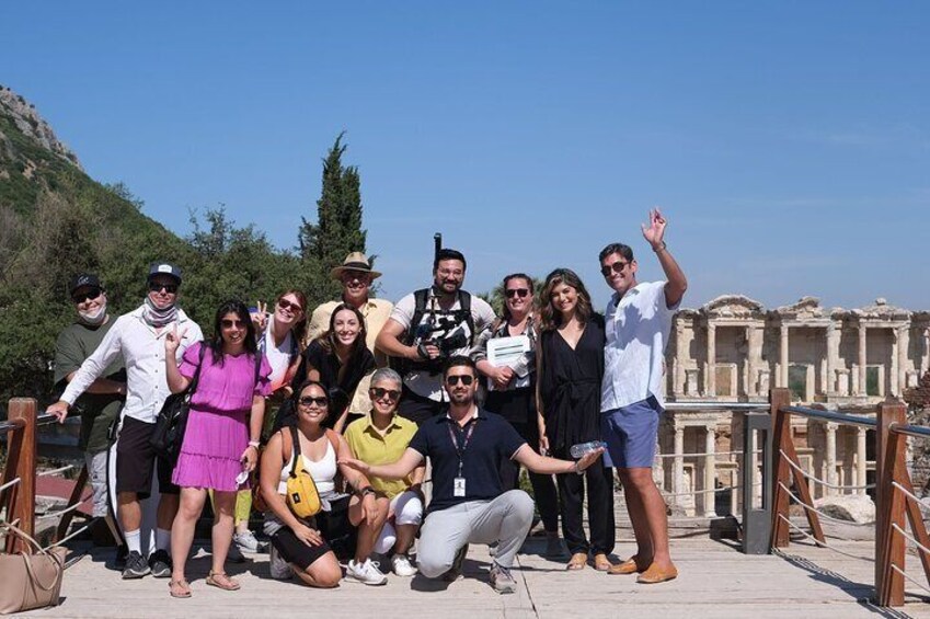 Un grupo de personas posando frente a ruinas antiguas con un cielo azul despejado al fondo. 5