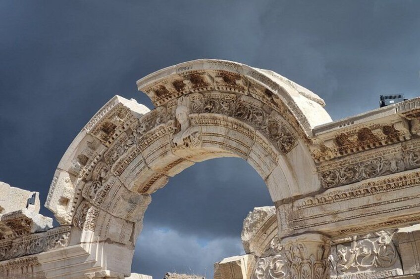 Un arc en pierre antique, orné de sculptures complexes, se dresse sous un ciel spectaculaire. 2