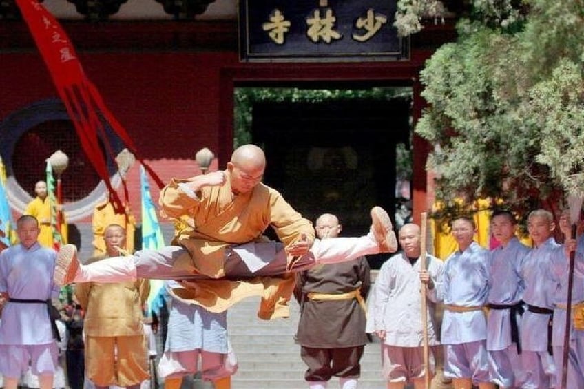 A martial arts demonstration with a person performing a high kick. 2