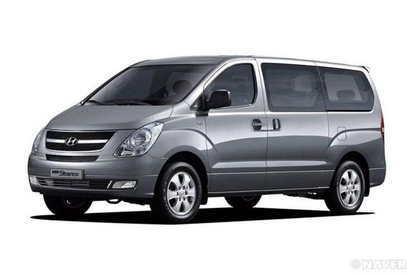 En sølvgrå Hyundai Starex varevogn med tydelig logo, sidespejle og hjul. 3