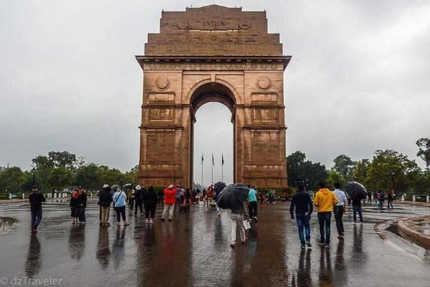 The India Gate in Delhi, India, with people walking around it. 2