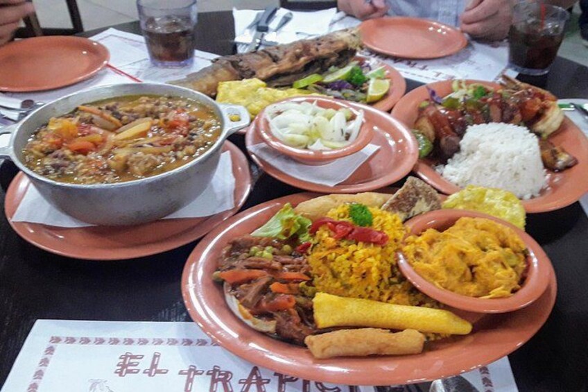 A table with various dishes including a bowl of soup, rice, and a plate with mixed vegetables and meat. 1