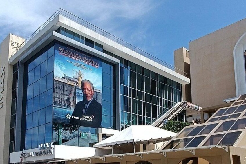 A modern building with a large billboard featuring a portrait and text. 5